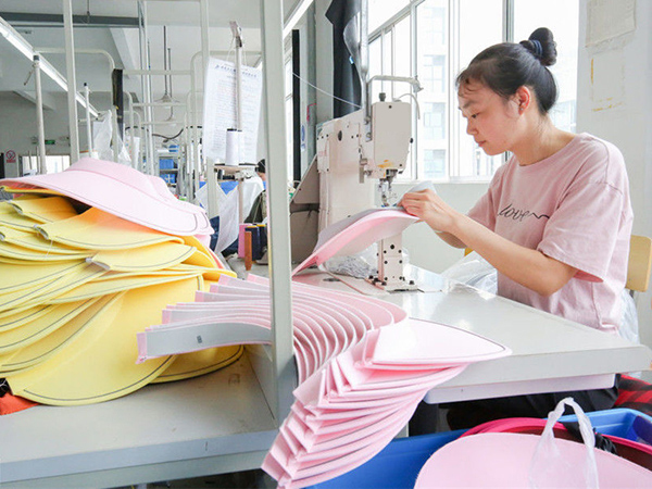 Skilled workers sew the fabric visors
